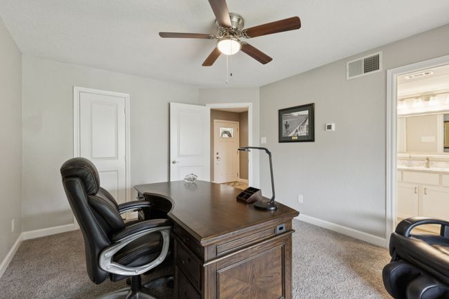 Carpeted office space with a ceiling fan and baseboards | Image 6