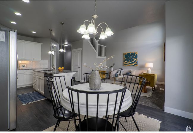 Dining room featuring dark wood-style flooring, baseboards, a chandelier, and recessed lighting | Image 8