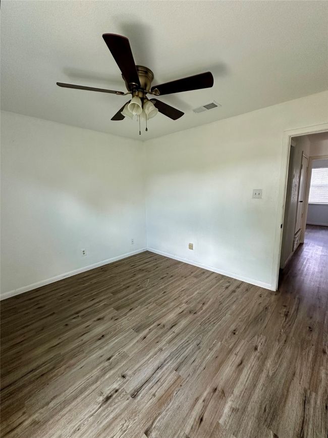 Empty room with wood finished floors and ceiling fan | Image 17