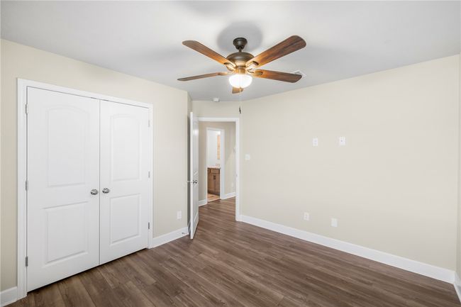 Unfurnished bedroom with dark wood-style flooring, baseboards, a closet, and ceiling fan | Image 21