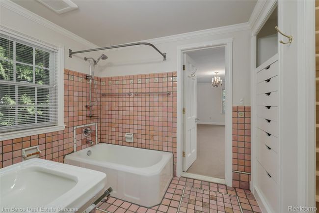 Bathroom featuring bathing tub / shower combination, tile walls, ornamental molding, light tile patterned floors, and a chandelier | Image 18