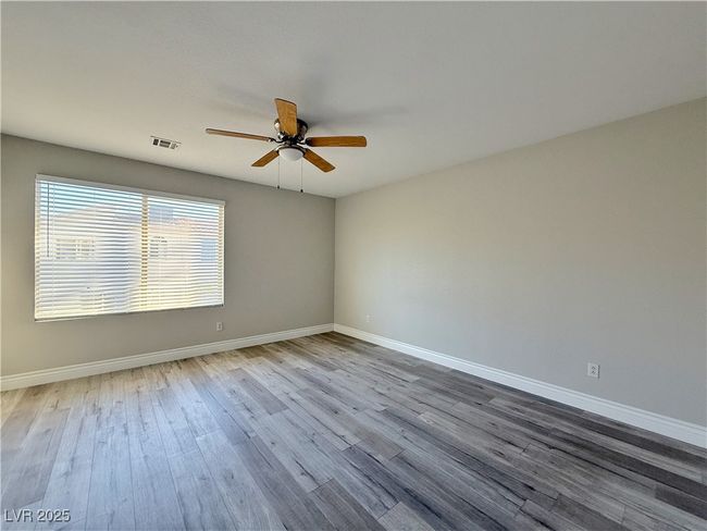 Spare room featuring wood finished floors, a ceiling fan, visible vents, and baseboards | Image 41