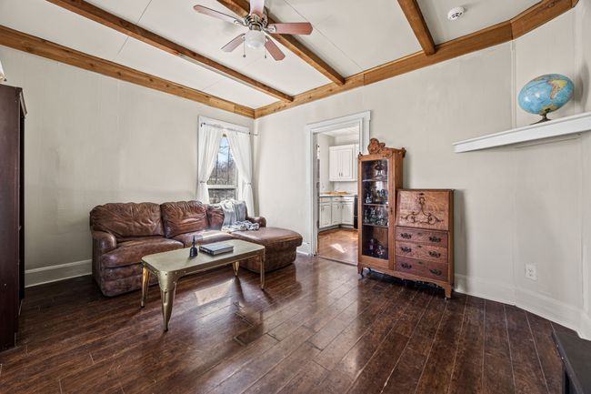 Living area with hardwood / wood-style flooring, baseboards, a ceiling fan, and beamed ceiling | Image 4