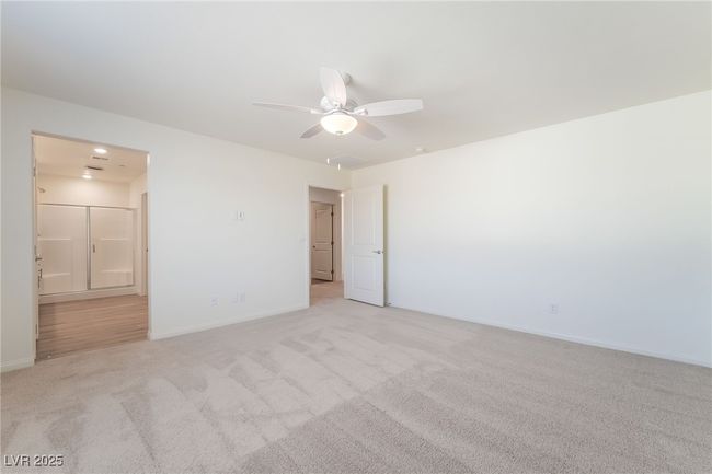 Unfurnished bedroom featuring light carpet, connected bathroom, and a ceiling fan | Image 21