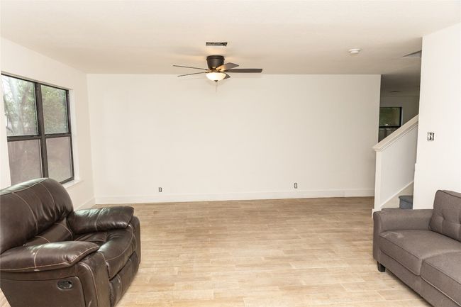 Living room featuring ceiling fan, stairway, and light wood-type flooring | Image 5