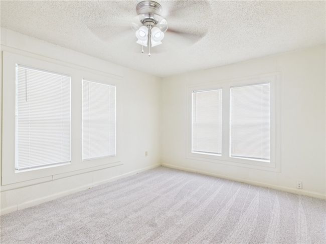 Spare room featuring light colored carpet, ceiling fan, and a textured ceiling | Image 12