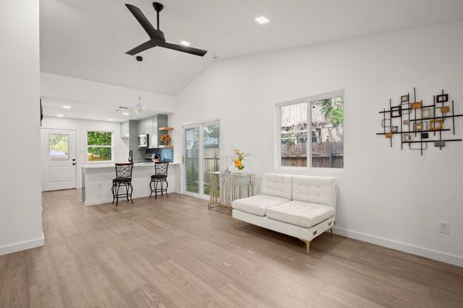 Living area with ceiling fan, light wood-style floors, recessed lighting, and high vaulted ceiling | Image 6