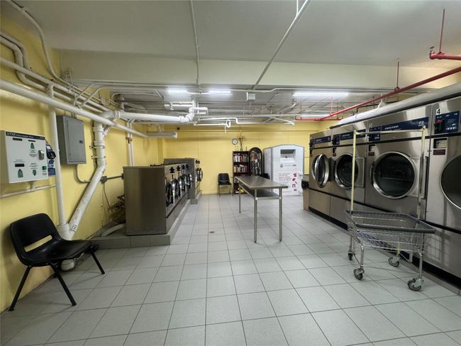 Community laundry room with washing machine and dryer, a garage, and electric panel | Image 9