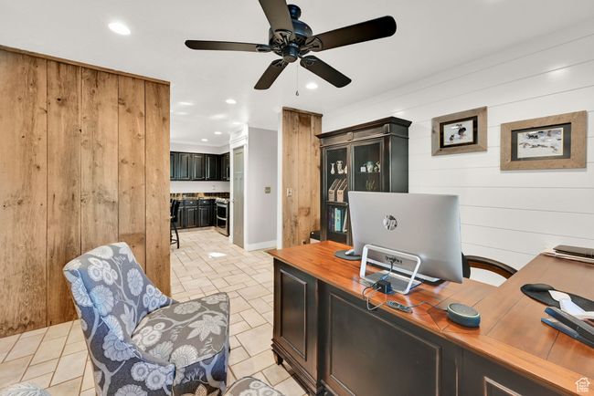 Office space with ceiling fan and wood walls | Image 15