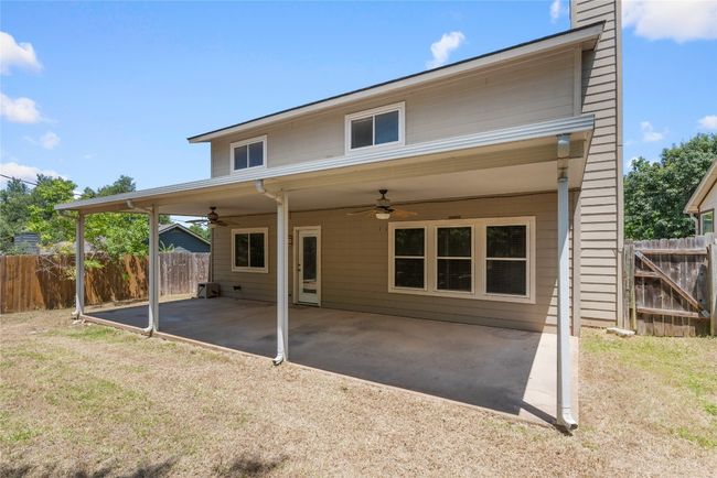 Rear view of house featuring ceiling fan, a patio area, and a chimney | Image 4