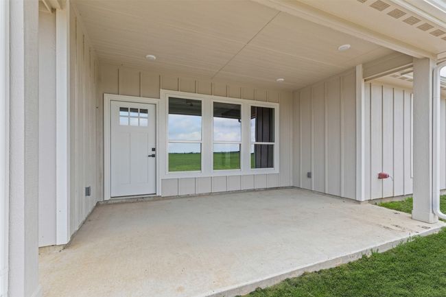 View of exterior entry with a patio and board and batten siding | Image 35