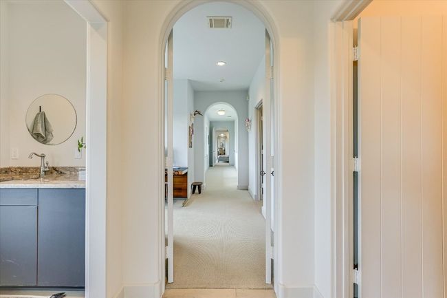 Corridor featuring arched walkways and light colored carpet | Image 27