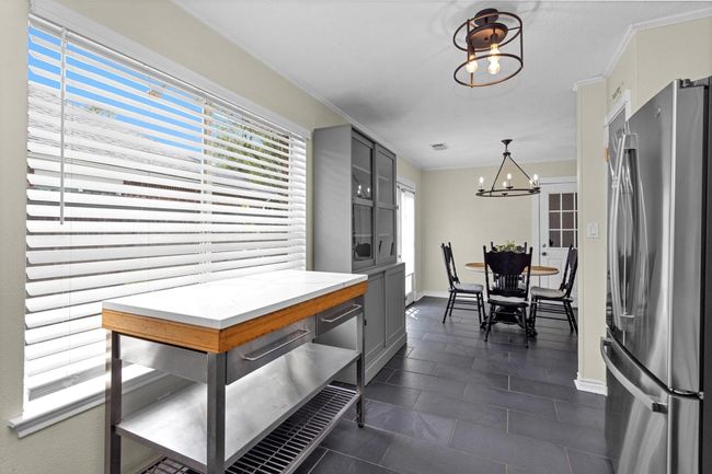 This charming kitchen is bathed in natural light thanks to a large window that offers lovely views and a fresh, airy feel. The window not only brightens the space but also creates a welcoming atmosphere, perfect for cooking and gathering. | Image 12
