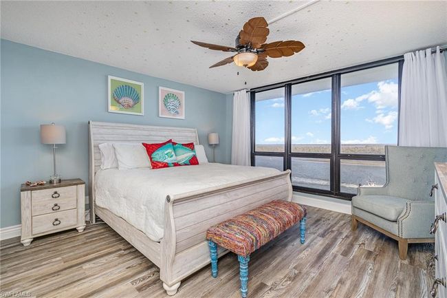 SPACIOUS OWNER'S SUITE HAS A NEARLY FULL WALL OF IMPACT RESISTANT WINDOWS WITH DIRECT ESTERO BAY VIEWS. EN-SUITE IS TO LEFT. | Image 12