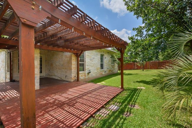 Step outside to your private backyard haven, where a pergola-covered deck and patio create the ideal setting for al fresco dining, morning coffee, or relaxing under the Texas sky. | Image 36