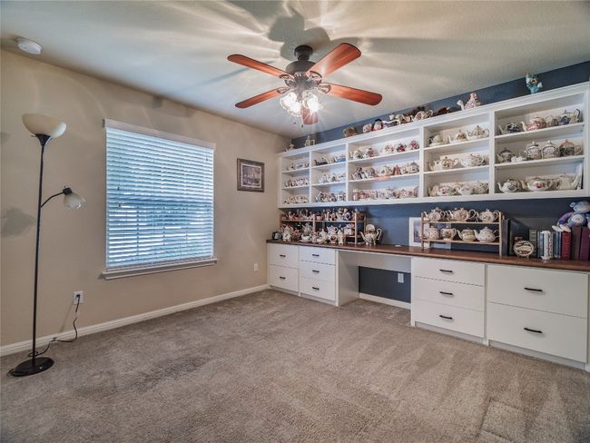 Unfurnished office with built in study area, light carpet, a ceiling fan, and baseboards | Image 8