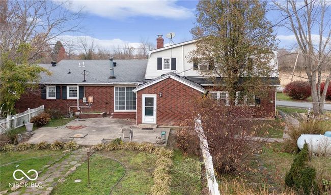 rear view of house with entry steps, a patio area, brick siding, and a chimney | Image 41