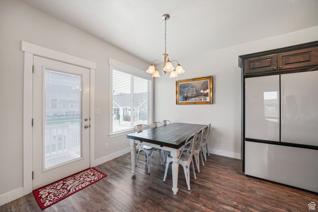 Dining space featuring a chandelier and dark wood finished floors | Image 9