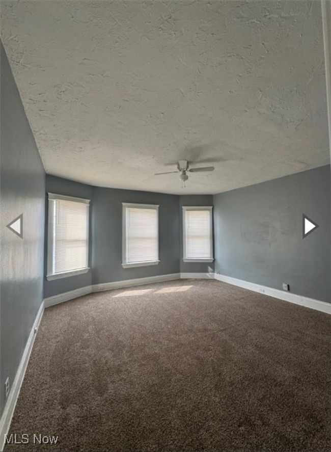 Carpeted spare room featuring ceiling fan and a textured ceiling | Image 5
