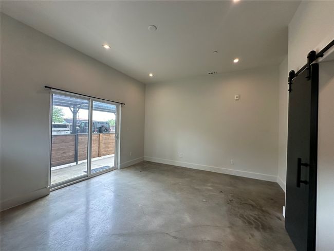 Empty room with a barn door, concrete flooring, and recessed lighting | Image 31