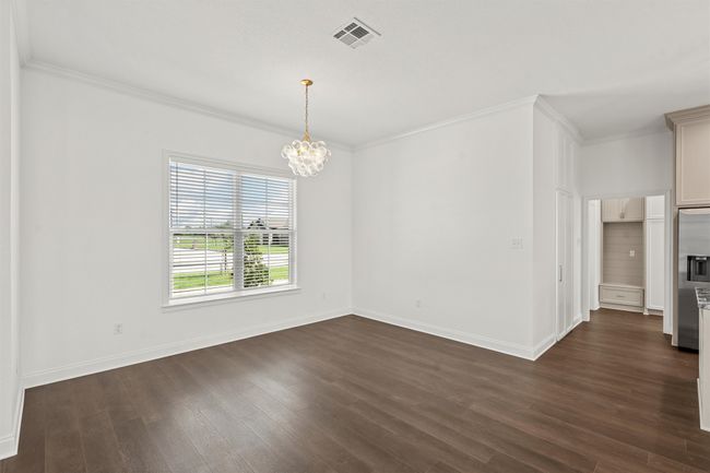 Spare room featuring a chandelier, dark wood-type flooring, and ornamental molding | Image 30