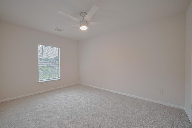 One of three secondary bedrooms upstairs, featuring closet space, all new carpet, freshly painted walls and ceiling, and a brand new ceiling fan for added comfort. | Image 27