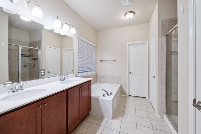 Full bath with tile patterned flooring, a shower stall, double vanity, and a garden tub | Image 26