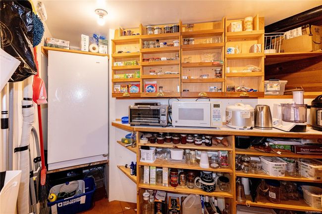 Behind a door is the walk-in pantry with custom slide out cupboards for maximum storage | Image 33