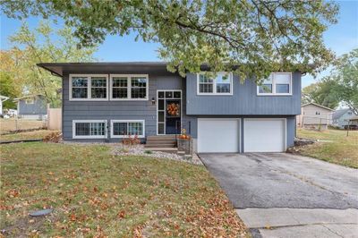 Bi-level home featuring a front lawn and a garage | Image 1