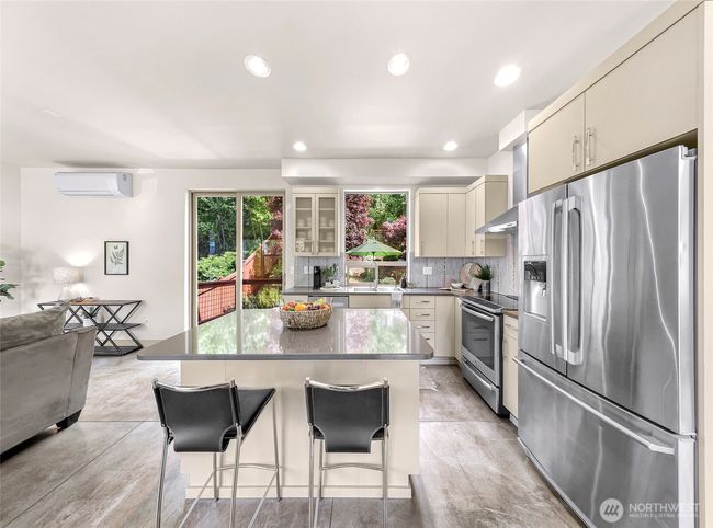 Beautiful kitchen with an island, quartz countertops, stainless steel appliances, gorgeous backsplash. | Image 4