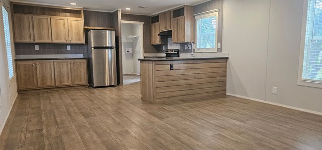 Kitchen with appliances with stainless steel finishes, dark countertops, backsplash, light wood-style floors, and recessed lighting | Image 16