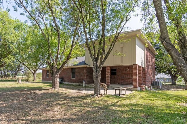 Back of property with brick siding, central AC unit, a lawn, and a patio | Image 20