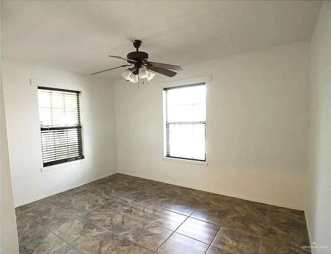Spare room featuring a ceiling fan | Image 6