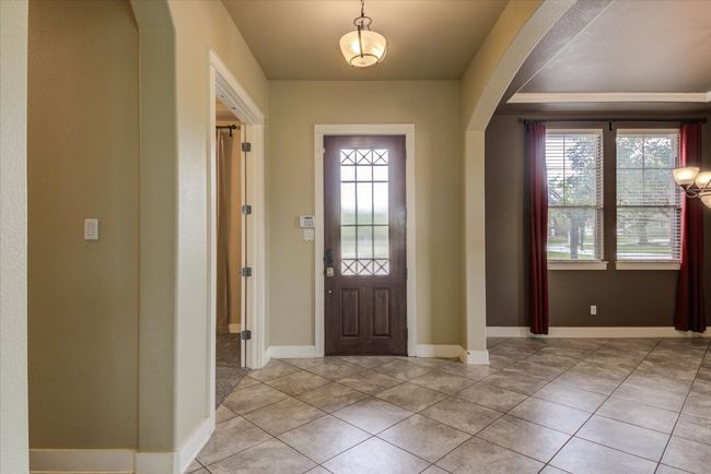 Entrance foyer with light tile patterned flooring, arched walkways, and a healthy amount of sunlight | Image 5