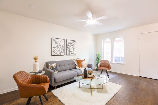 Living area with dark engineered hardwood floors and ceiling fan. | Image 21