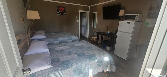 Bedroom featuring freestanding refrigerator and wood finished floors | Image 20