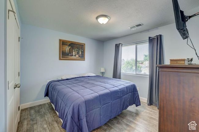Bedroom with visible vents, baseboards, wood finished floors, and a textured ceiling | Image 21