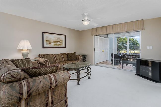 Living area featuring light carpet and ceiling fan | Image 9
