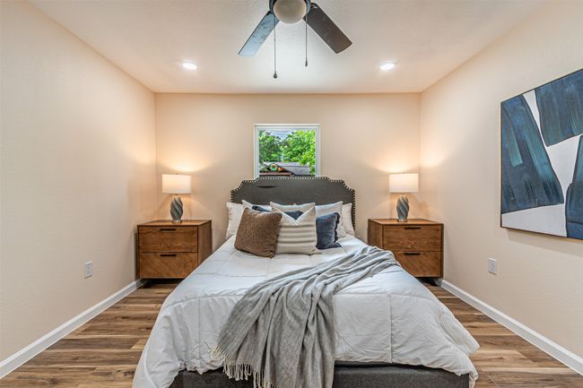 Bedroom with ceiling fan, baseboards, and wood finished floors | Image 14