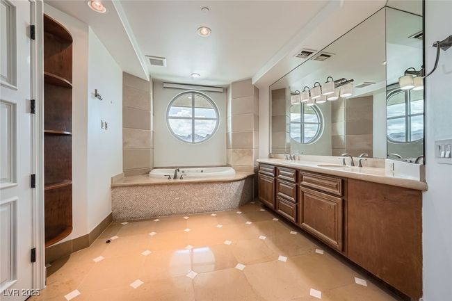 Bathroom featuring a bath, double vanity, tile patterned floors, and baseboards | Image 19