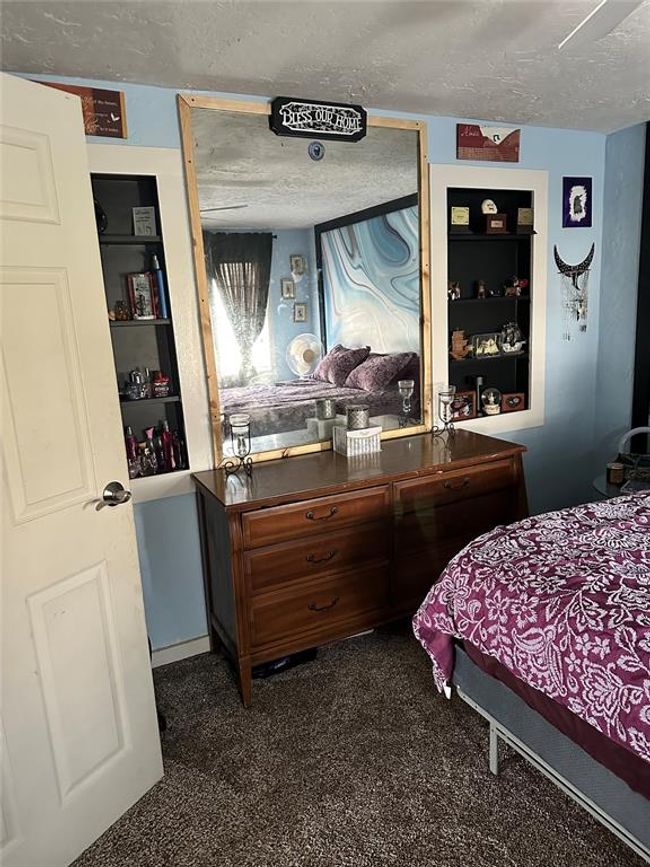 Bedroom featuring a textured ceiling and dark colored carpet | Image 21