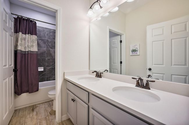 Guest bathroom features double sinks with a private toilet and shower space | Image 27