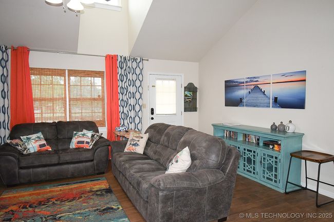 Living area featuring wood finished floors, vaulted ceiling, and a ceiling fan | Image 6