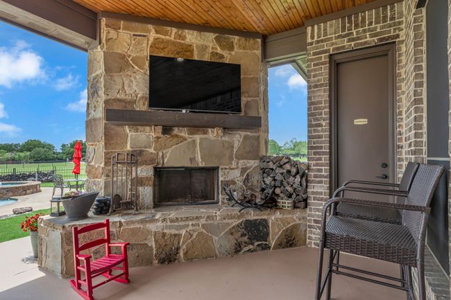 View of patio with an outdoor stone fireplace | Image 33