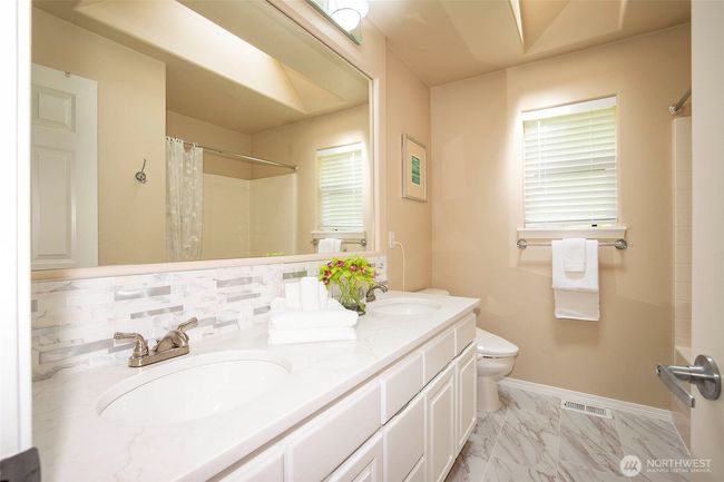 Upstairs Hall Bath with Double Sinks & Stone Counters & Tub/Shower Enclosure & Tile Floors. | Image 25