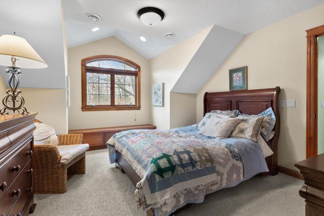 Upper-level first bedroom with view to front yard and large natural pond. Walk-in closet. | Image 35