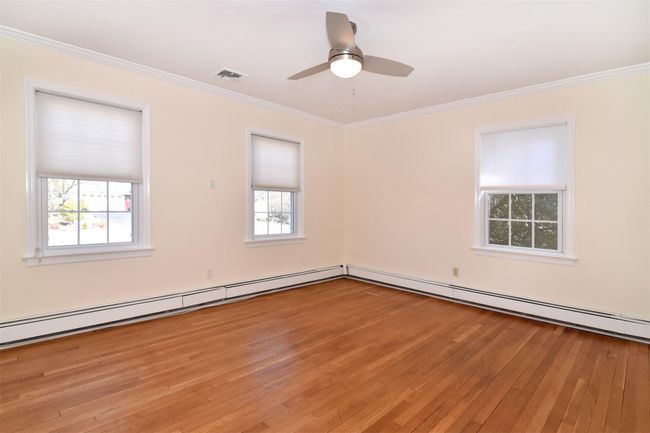First Floor bedroom featuring visible vents, light wood-style flooring, ceiling fan, and ornamental molding | Image 12