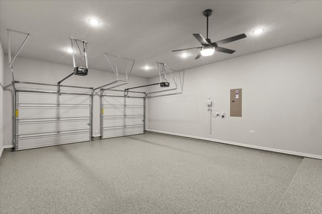 Garage featuring a garage door opener, epoxy flooring, a ceiling fan, and recessed lighting | Image 30