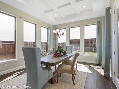 Dining area featuring a notable chandelier, beam ceiling, hardwood / wood-style flooring, and coffered ceiling | Image 3