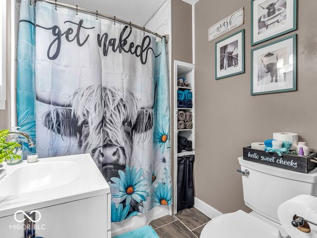 full bathroom featuring renovated tiled tub/shower, toilet, flooring and vanity | Image 14